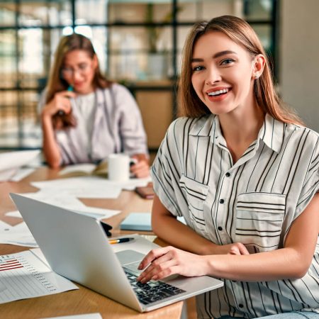 Smiling woman using laptop to make an insurance claim